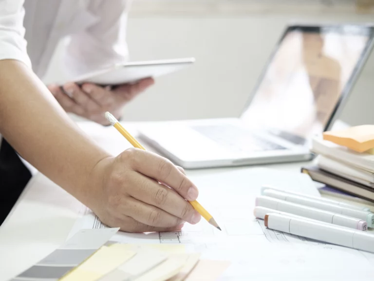 Przykład profesjonalnego projektowania składu książki z tekstem i ilustracjami na otwartej książce i komputerze z programem do składu książki.