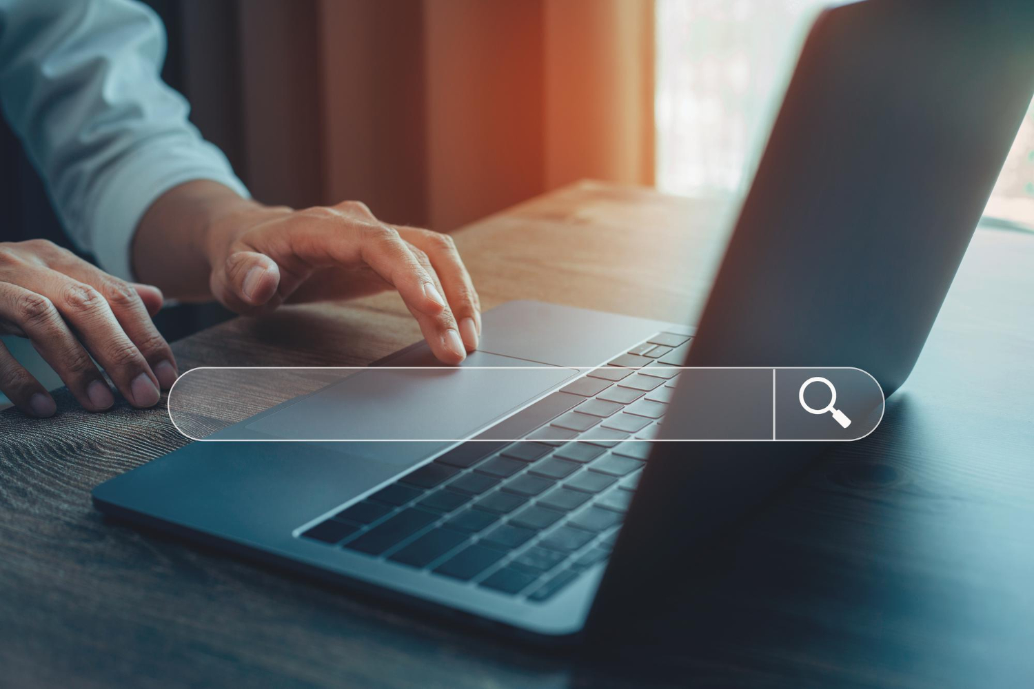 Osoba przeszukująca internet na laptopie – symboliczne przedstawienie procesu wyboru słów kluczowych dla strony internetowej firmy lokalnej.